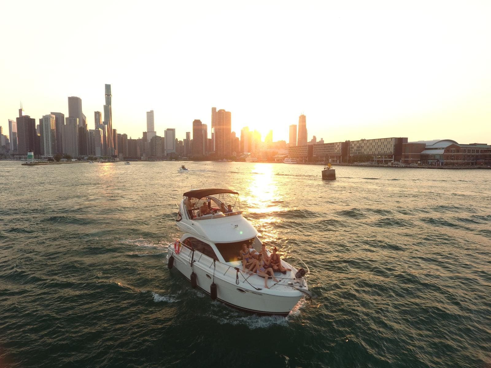 Chicagoland Yacht Rental cruising Lake Michigan with Chicago skyline at sunset